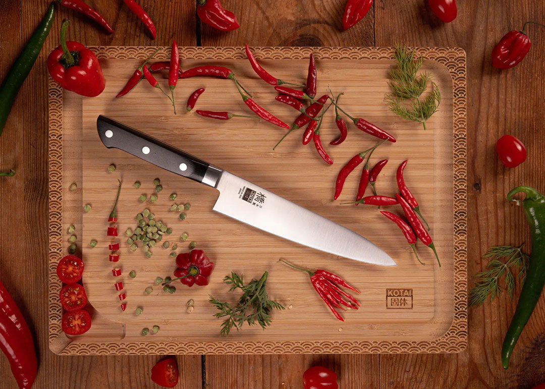 KOTAI Hashi Koksmes Gyuto met 18 cm lemmet en zwart heft op houten snijplank